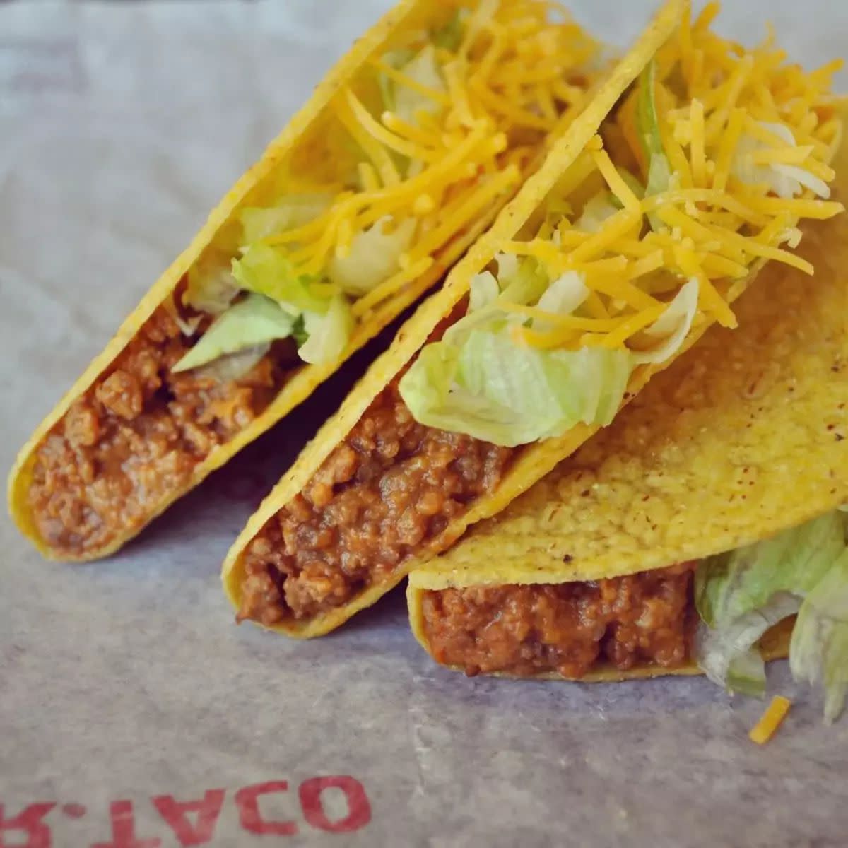 Closeup of three Taco Bell Crunchy Tacos on wrapping paper