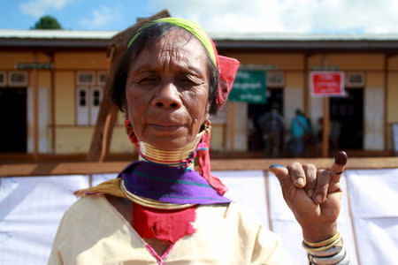 A Kayan woman, from one of Myanamr's ethnic minority groups, shows her inked finger after casting her vote outside a polling station in Loikaw, November 8, 2015. REUTERS/Stringer