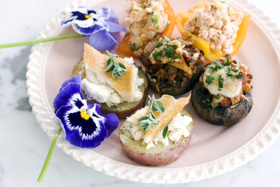 In this image taken on April 22, 2013, smoked schmeared potatoes, chorizo hash stuffed mushroom caps, middle, and stuffed baby bell peppers, rear, are shown served on a plate in Concord, N.H. (AP Photo/Matthew Mead)