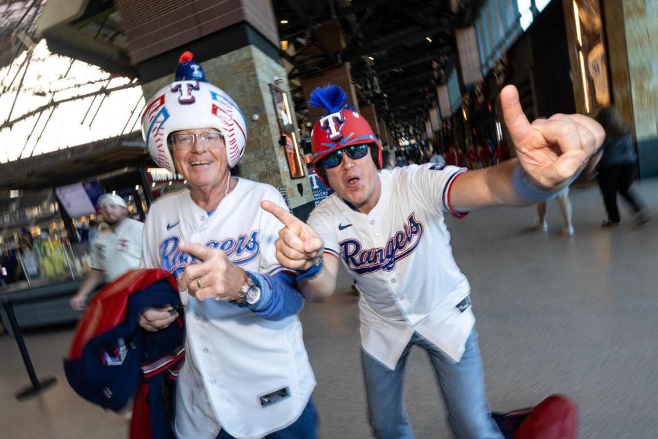 Father and son Galen and Christopher Killion cheer as they enter the stadium with their custom made Texas Rangers helmets for the 2024 season opener between the Rangers and the Chicago Cubs at Globe Life Field in Arlington on Thursday, March 28, 2024. Chris Torres/ctorres@star-telegram.com