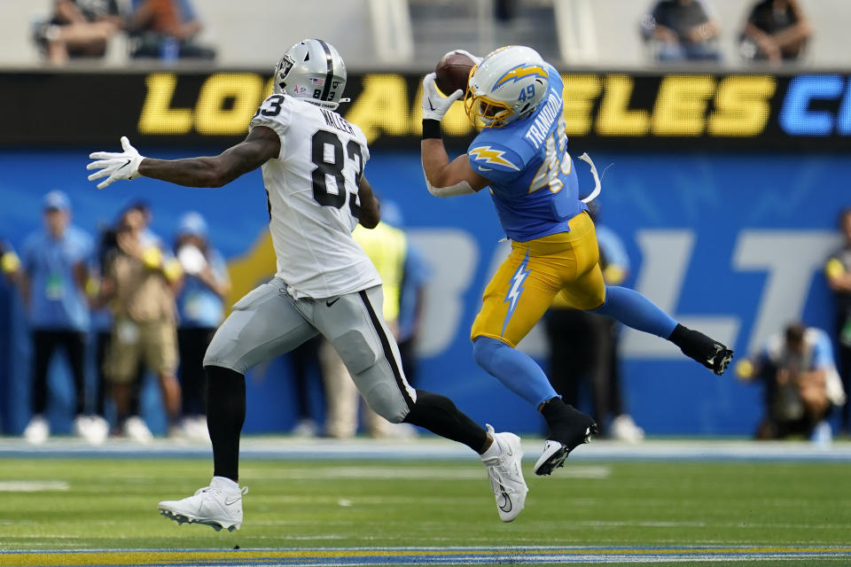 Los Angeles Chargers linebacker Drue Tranquill, right, intercepts a pass in front of Las Vegas Raiders tight end Darren Waller (83) during the first half of an NFL football game in Inglewood, Calif., Sunday, Sept. 11, 2022. (AP Photo/Marcio Jose Sanchez)