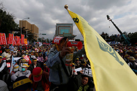 REFILE - ADDING DROPPED WORD Protesters take part in a rally against the overhaul of the military and civil service pension fund, outside the Presidential Office in Taipei,Taiwan January 22, 2017. REUTERS/Tyrone Siu