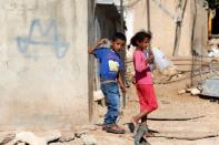 Palestinian children carry water bottles near their house on the outskirts of the West Bank village of Yatta, south of Hebron, August 17, 2016. REUTERS/Mussa Qawasma