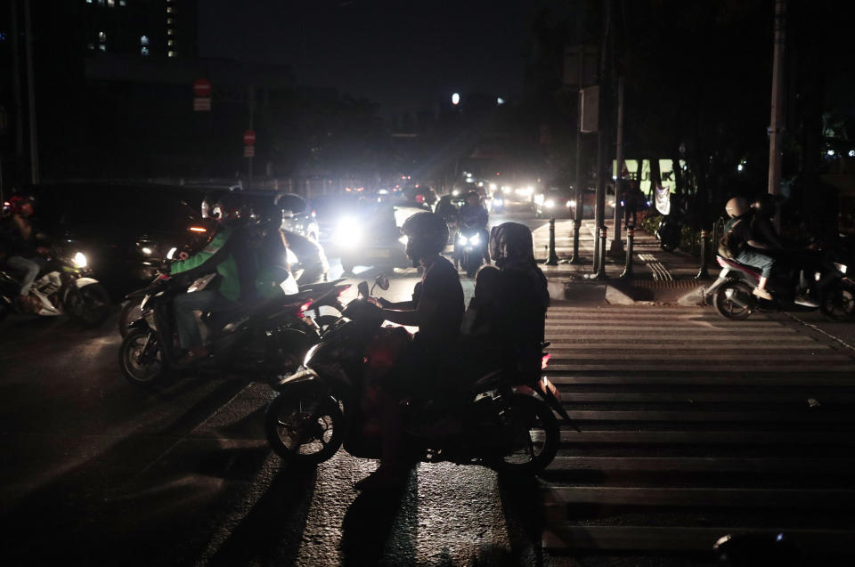 Motorists navigate through traffic during a power outage in Jakarta, Indonesia, Sunday, Aug. 4, 2019. Indonesia's sprawling capital and other parts of Java island have been hit by a massive power outage affecting millions of people. (AP Photo/Dita Alangkara)