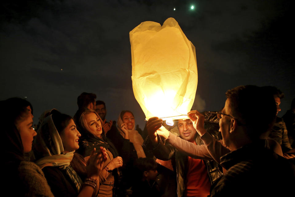 Iranians release a lit lantern during a celebration, known as "Chaharshanbe Souri," or Wednesday Feast, Tuesday, March 19, 2019, marking the eve of the last Wednesday of the solar Persian year, in Tehran, Iran. Iran's many woes briefly went up in smoke on Tuesday as Iranians observed a nearly 4,000-year-old Persian tradition known as the Festival of Fire. (AP Photo/Ebrahim Noroozi)