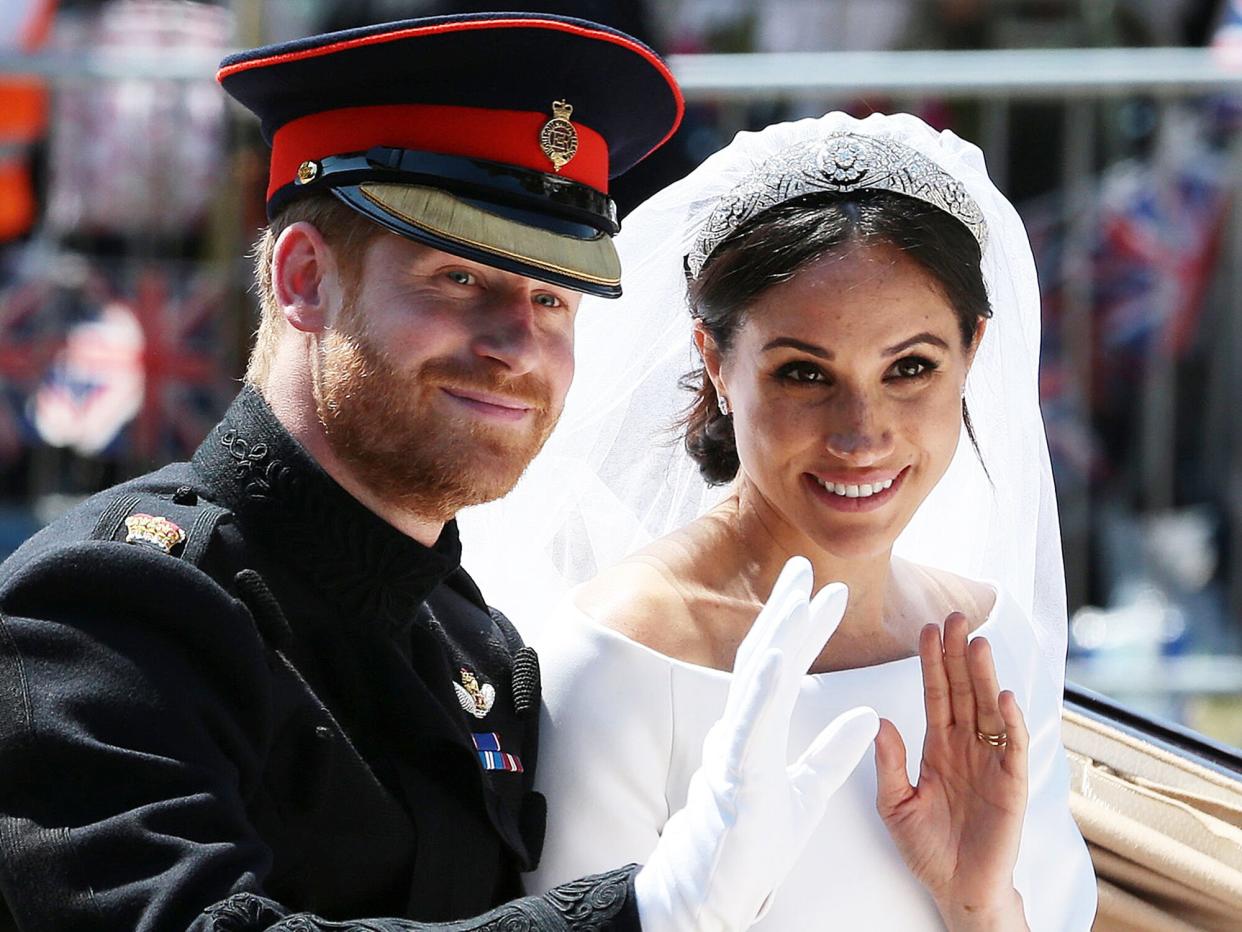 Prince Harry, Duke of Sussex and his wife Meghan, Duchess of Sussex wave from the Ascot Landau Carriage during their carriage procession on the Long Walk as they head back towards Windsor Castle in Windsor, on May 19, 2018 after their wedding ceremony