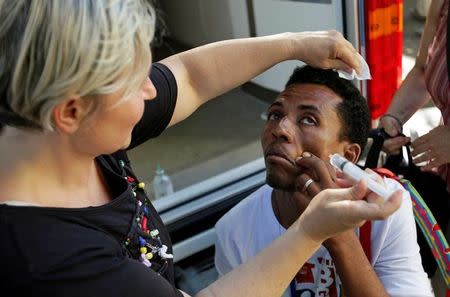 A migrant has his eyes washed by a volunteer at a makeshift camp in Via Cupa (Gloomy Street) in downtown Rome, Italy, August 1, 2016. REUTERS/Max Rossi