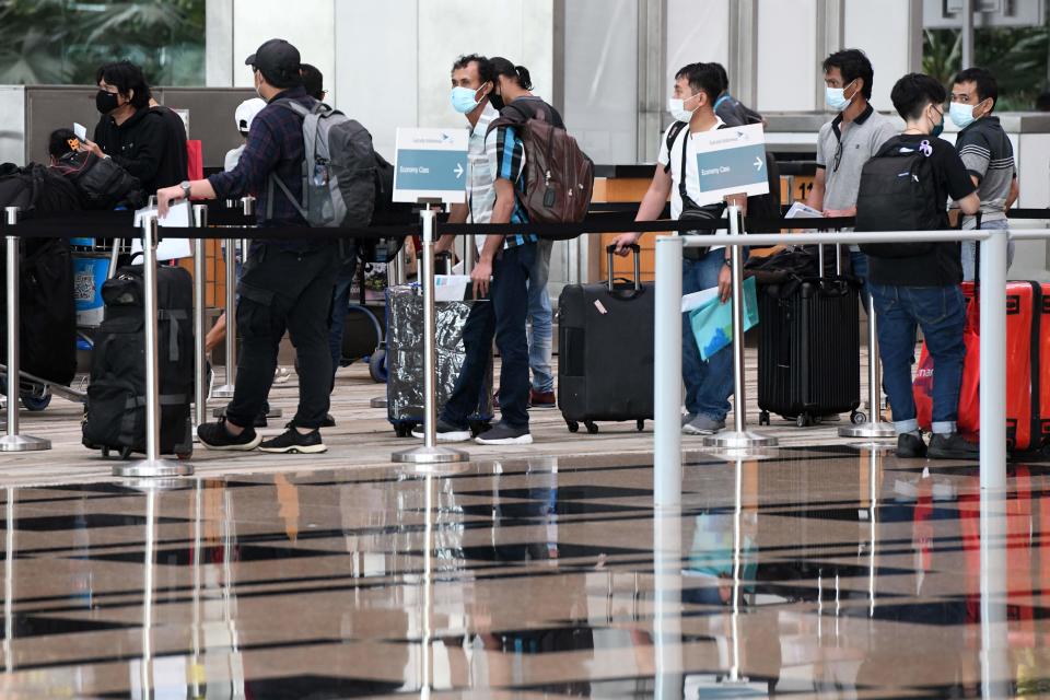 Passengers a check-in counter at Changi International Airport. 