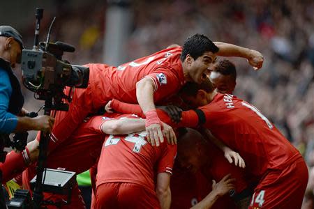 Liverpool's Philippe Courtinho (obscured) celebrates scoring against Manchester City with teammates during their English Premier League soccer match at Anfield in Liverpool, northern England April 13, 2014. REUTERS/Nigel Roddis