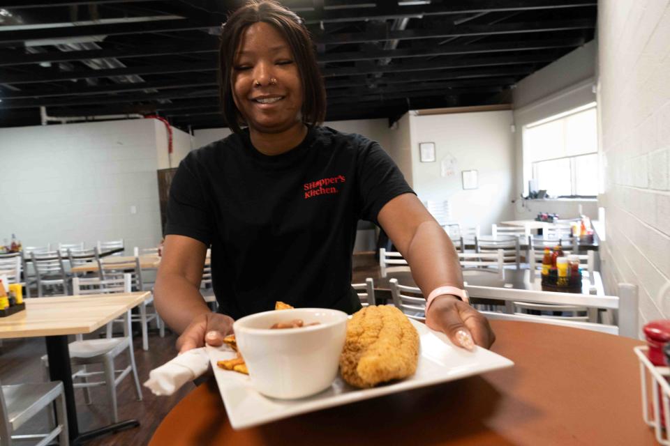 Server Cierra Martinez brings a catfish meal, complete with two sides for $18.99, is brought to the table Wednesday at SHopper's Kitchen, 250 S.E. 29th St.