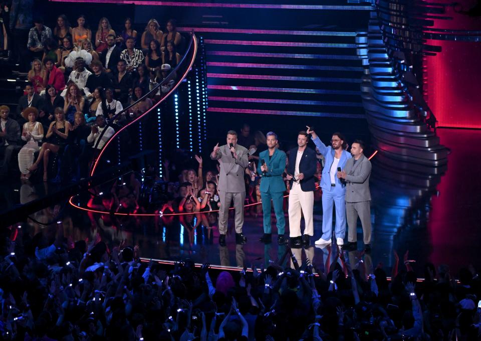 (L-R) Joey Fatone, Lance Bass, Justin Timberlake, JC Chasez and Chris Kirkpatrick of NSYNC speak onstage before presenting Taylor Swift an award.