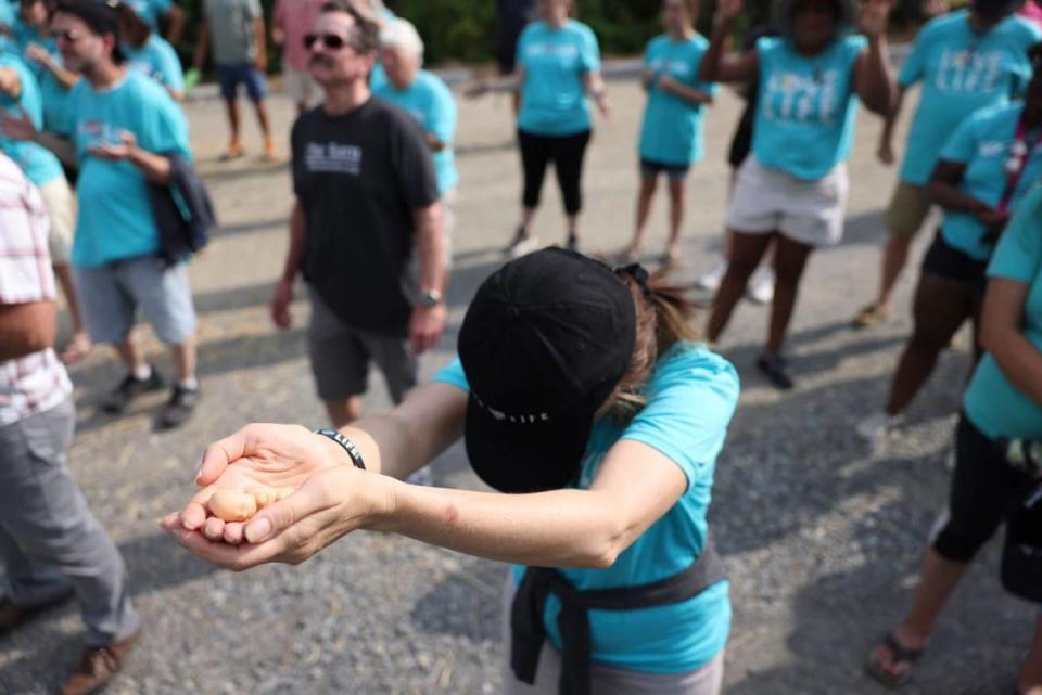 A woman extends a representation of a miniature baby in her hands outside of A Preferred Women’s Health Center of Charlotte on Saturday.