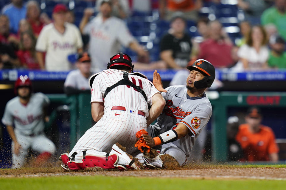 Baltimore Orioles' Pedro Severino, right, is tagged out at home by Philadelphia Phillies catcher J.T. Realmuto after trying to score on a single by Pat Valaika during the eighth inning of an interleague baseball game, Wednesday, Sept. 22, 2021, in Philadelphia. (AP Photo/Matt Slocum)