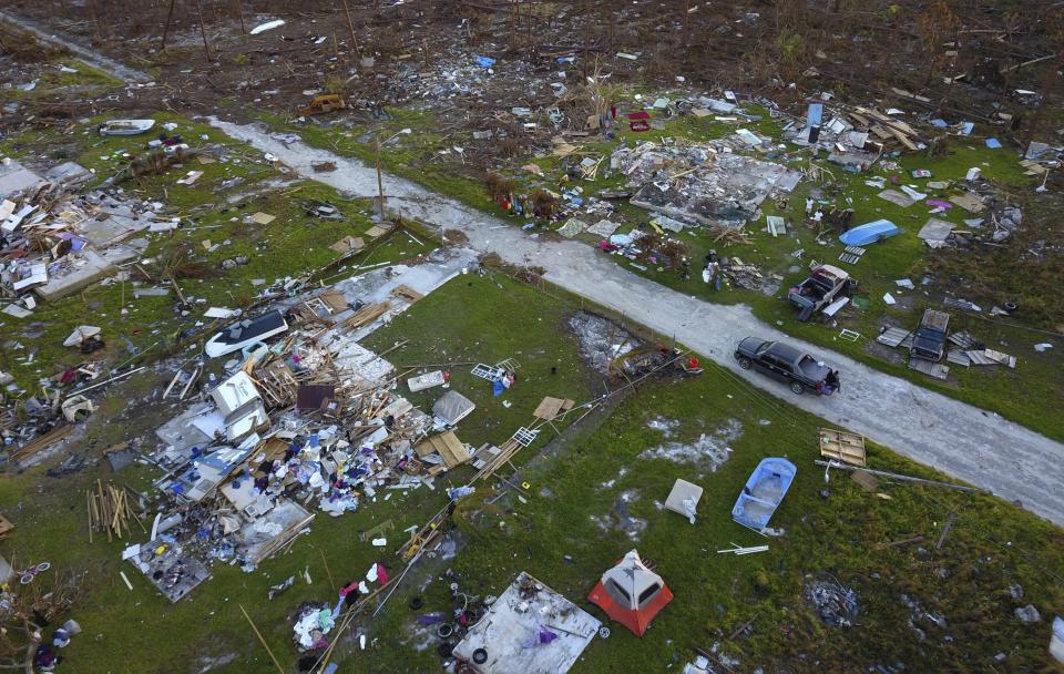 A road cuts through the rubble of homes that belong to the same family, destroyed by Hurricane Dorian in Rocky Creek East End, Grand Bahama, Bahamas, Sunday, Sept. 8, 2019. Bahamians are searching the rubble, salvaging the few heirlooms left intact by the Category 5 storm. (AP Photo/Ramon Espinosa)