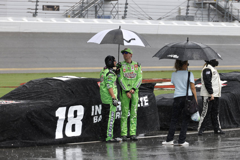 Kyle Busch stands next to his car on pit road after a thunderstorm caused a red flag stoppage during a NASCAR Cup Series auto race at Daytona International Speedway, Sunday, Aug. 28, 2022, in Daytona Beach, Fla. (AP Photo/Terry Renna)