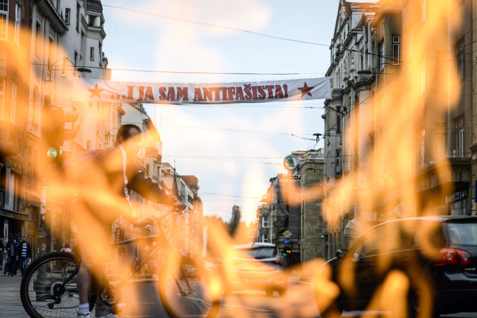 The Eternal flame, a memorial to the military and civilian victims of the Second World War, is backdropped by a banner that reads "I too am an anti-Fascist", near the Sacred Heart Cathedral in Sarajevo, Bosnia, Saturday, May 16, 2020, ahead of the commemoration Mass for Croatian pro-Nazis killed at the end of World War II. The controversial gathering of Croatia's far-right supporters has been held annually in the southern Austrian village of Bleiburg, but had to be moved to Sarajevo and the Croatian capital, Zagreb, for next Saturday because of travel restrictions and a ban on mass gatherings during the coronavirus crisis. A leading Jewish human rights group said that honoring Croatia's World War II pro-Nazi regime is an insult to its victims. Tens of thousands of Jews, Serbs, Gypsies and anti-fascist Croats perished in the death camps in Croatia during the war. (AP Photo/Kemal Softic)