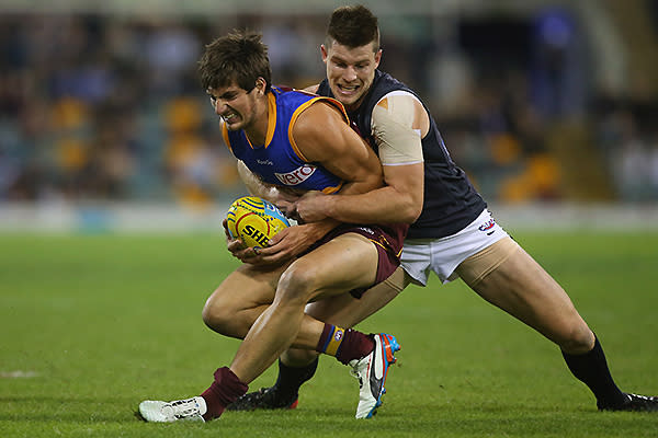 Sam Mayes of the Lions is tackled by Bryce Gibbs of the Blues and caught holding the ball.