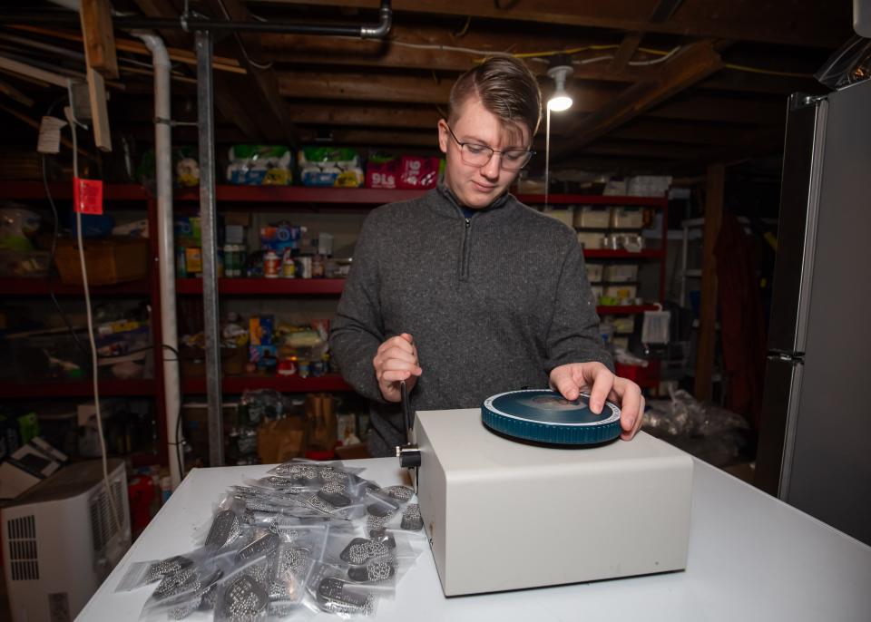 Connor Nicol, 15, of Hampton, shows how he can make 20 to 30 dog tags per hour using his embosser, which he keeps on top of the family freezer. Connor was named November’s Granite Stater of the Month by U.S. Senator Maggie Hassan for his project of making more than 50,000 dog tags to honor service members who died in wars overseas.