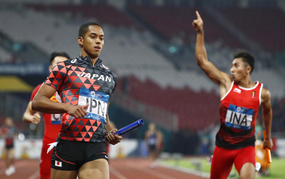 Japan's Asaka Cambridge, left, crosses the finish line to win the men's 4x100m relay gold during the athletics competition at the 18th Asian Games in Jakarta, Indonesia, Thursday, Aug. 30, 2018. (AP Photo/Bernat Armangue)