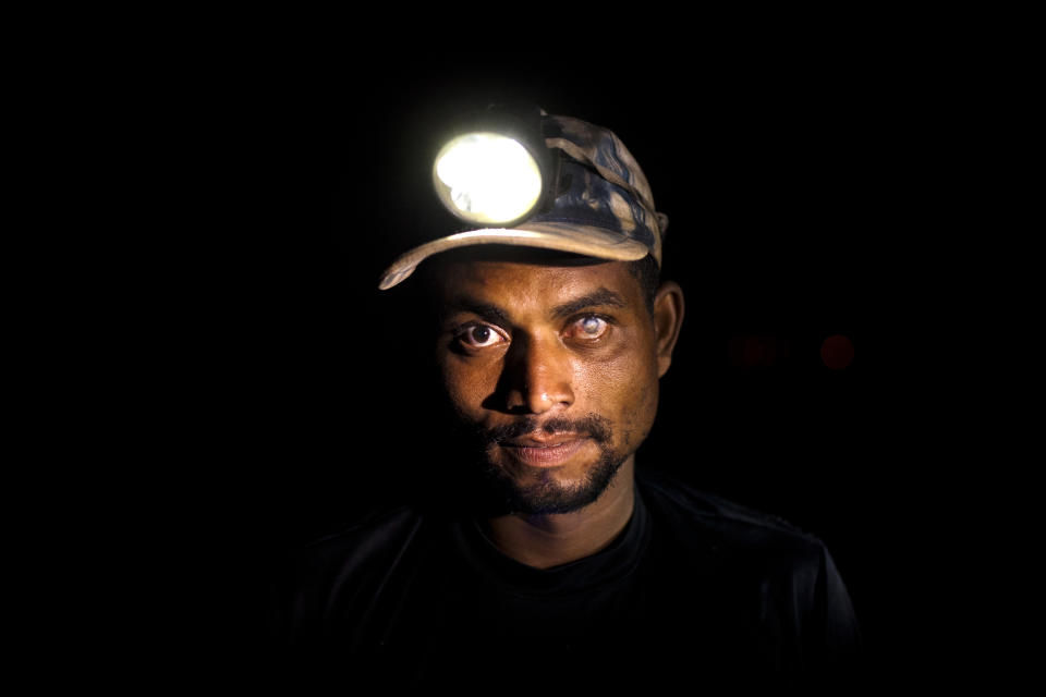 In this May 29, 2012 photo, Wallace de Souza, 34, poses for a portrait at the Jardim Gramacho, one of the world's largest open-air landfills, in Rio de Janeiro, Brazil. Jardim Gramacho, a vast, seaside mountain of trash where thousands of people made a living sorting through the debris by hand, is closing after three decades in service. Souza lost his sight in his left eye when acid splashed his eye while searching for recyclable materials at the dump. (AP Photo/Victor R. Caivano)