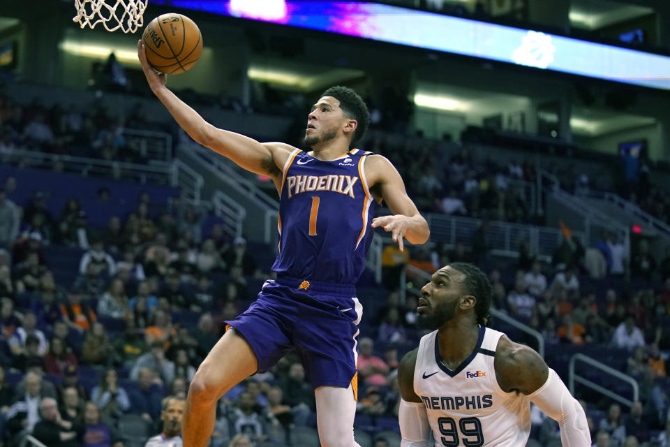 CORRECTS TO SAY THE GRIZZLIES WON, NOT THE SUN - Phoenix Suns guard Devin Booker drives past Memphis Grizzlies forward Jae Crowder (99) in the second half during an NBA basketball game, Sunday, Jan. 5, 2020, in Phoenix. The Grizzlies won 121-114. (AP Photo/Rick Scuteri)