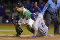 Texas Rangers' Marcus Semien (2) scores against Oakland Athletics catcher Sean Murphy during the eighth inning of a baseball game in Oakland, Calif., Friday, May 27, 2022. (AP Photo/Jeff Chiu)