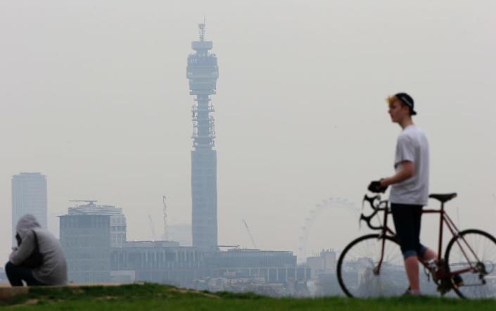 A cyclist pictured at the top of Primrose Hill in London on April 3, 2014 as the city below lies shrouded in pollution (AFP Photo/Adrian Dennis)
