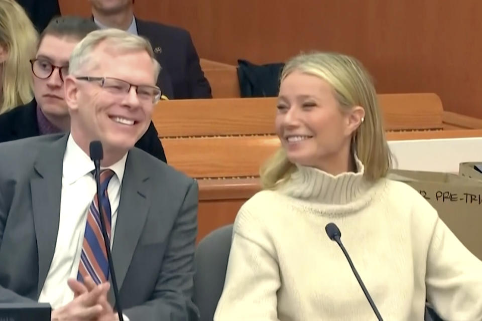 In this image taken from pool video, actor Gwyneth Paltrow, right, and her attorney Steve Owens smile during a hearing, Tuesday, March 21, 2023, in Park City, Utah, where she is accused in a lawsuit of crashing into a skier during a 2016 family ski vacation, leaving him with brain damage and four broken ribs. Terry Sanderson claims that the actor-turned-lifestyle influencer was cruising down the slopes so recklessly that they violently collided, leaving him on the ground as she and her entourage continued their descent down Deer Valley Resort, a skiers-only mountain known for its groomed runs, après-ski champagne yurts and posh clientele. (Pool Video via AP)