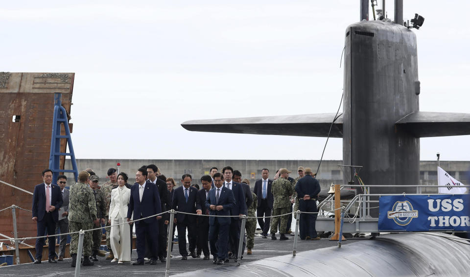 FILE - South Korean President Yoon Suk Yeol, center right, and his wife Kim Keon Hee, center left, board the USS Kentucky, a nuclear-powered ballistic missile submarine, at the South Korean naval operations base in Busan, South Korea, on July 19, 2023. (Lim Hun-jung/ Yonhap via AP, File)