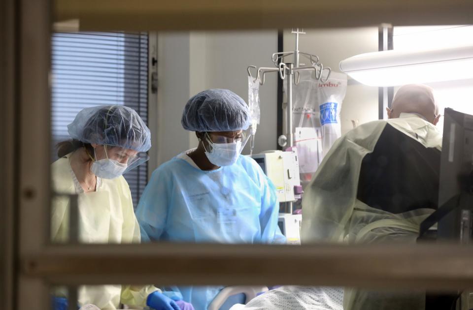 Vanessa Jean-Baptiste, a registered nurse in the intensive care unit at Northern Westchester Hospital in Mount Kisco, tends to a COVID-positive patient in the ICU's Trauma Room 7 on March 1, 2022.