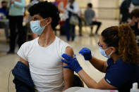 FILE - In this May 11, 2021, file photo, Nawaf Albarakati, 17, of Narberth, Pa., reacts as he receives a Pfizer COVID-19 vaccination from registered nurse Alicia Jimenez at a Montgomery County, Pa., Office of Public Health vaccination clinic at the King of Prussia Mall in King of Prussia., Pa. COVID-19 deaths in the U.S. have tumbled to an average of just over 600 per day — the lowest level in 10 months — with the number of lives lost dropping to single digits in well over half the states and hitting zero on some days. (AP Photo/Matt Slocum, File)