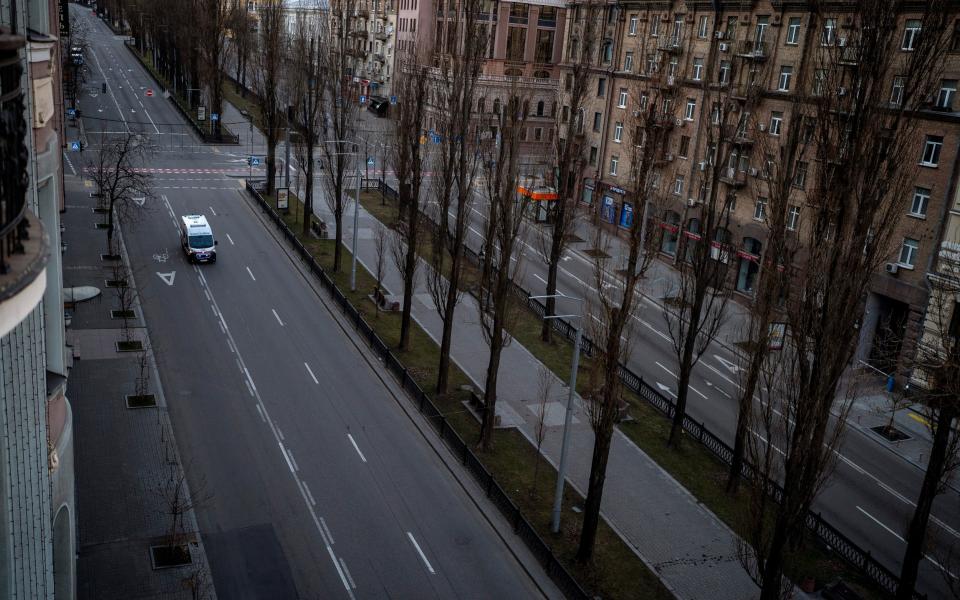 An emergency vehicle drives on an empty street during a curfew in the central of Kyiv, Ukraine, on Sunday - Emilio Morenatti/AP