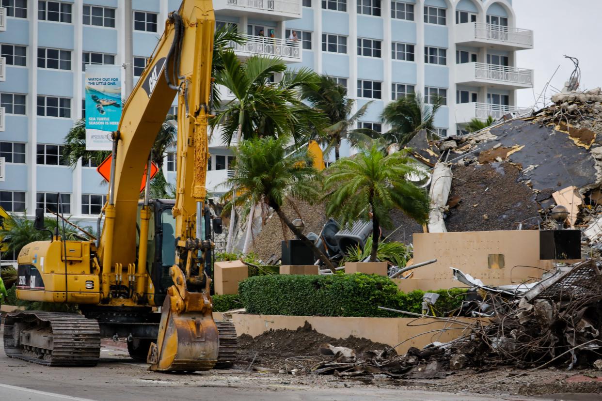 A bulldozer is parked next to the rubble of the collapsed building Champlain tower in Surfside, Fla on July 6, 2021.