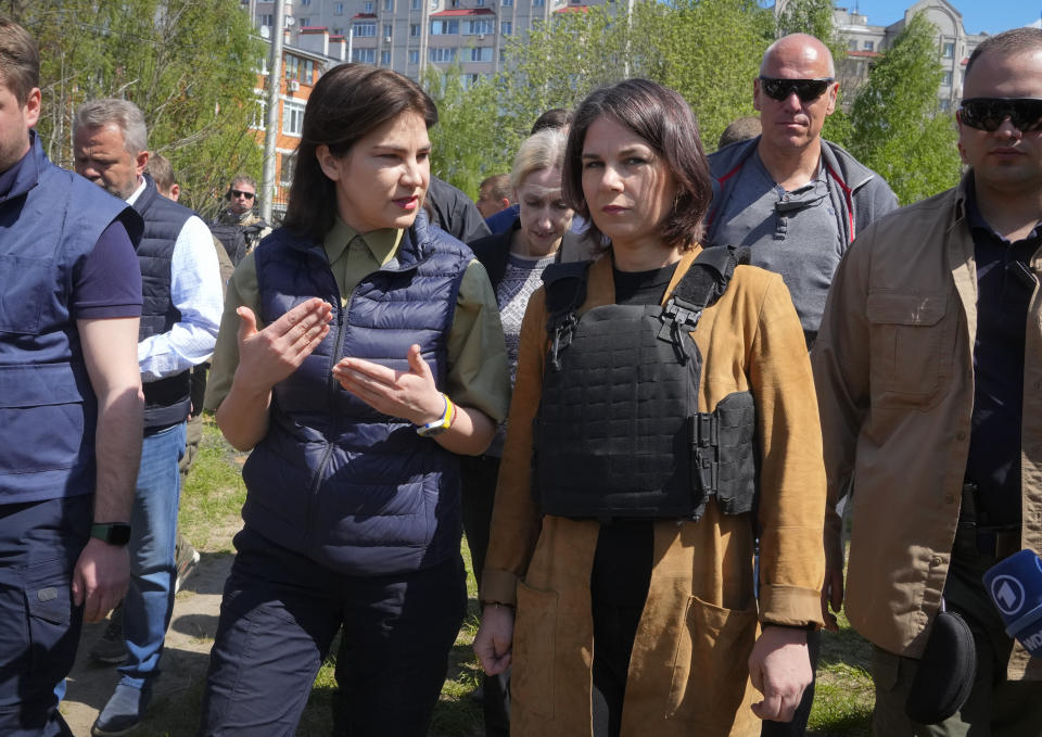 German Foreign Minister Annalena Baerbock, right, and Ukrainian Prosecutor General Iryna Venediktova talk as they stand near a mass grave in Bucha, on the outskirts of Kyiv, Ukraine, Tuesday, May 10, 2022. (AP Photo/Efrem Lukatsky)