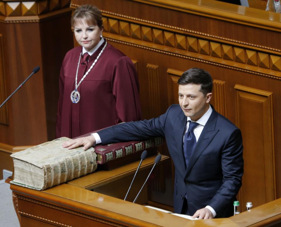 Ukrainian President-elect Volodymyr Zelenskiy swears on the Bible as he takes the oath of office during his inauguration ceremony in Kiev, Ukraine, Monday, May 20, 2019. Television star Volodymyr Zelenskiy has been sworn in as Ukraine's next president after he beat the incumbent at the polls last month. The ceremony was held at Ukrainian parliament in Kiev on Monday morning. (AP Photo/Efrem Lukatsky)