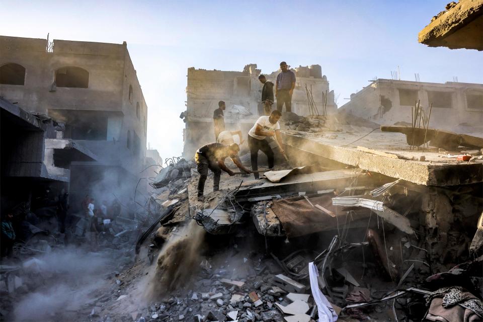 People dig and search through the rubble of a destroyed building following Israeli bombardment in Rafah (AFP via Getty Images)