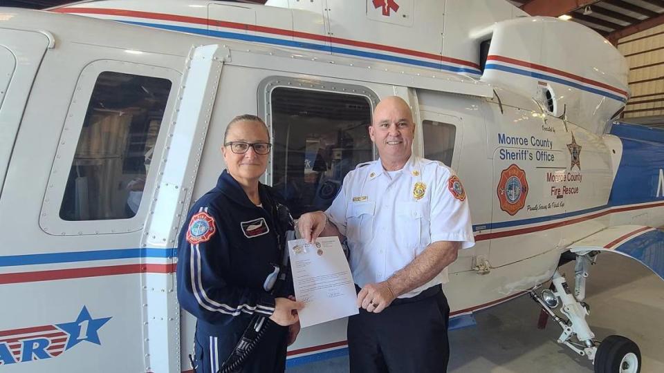 In this April 2022 photo posted on Monroe County Fire Rescue’s Facebook page, Lynda Rusinowski, left, is being commended for five years of service with the Trauma Star air ambulance program in the Florida Keys. At the time, she was the chief flight nurse.