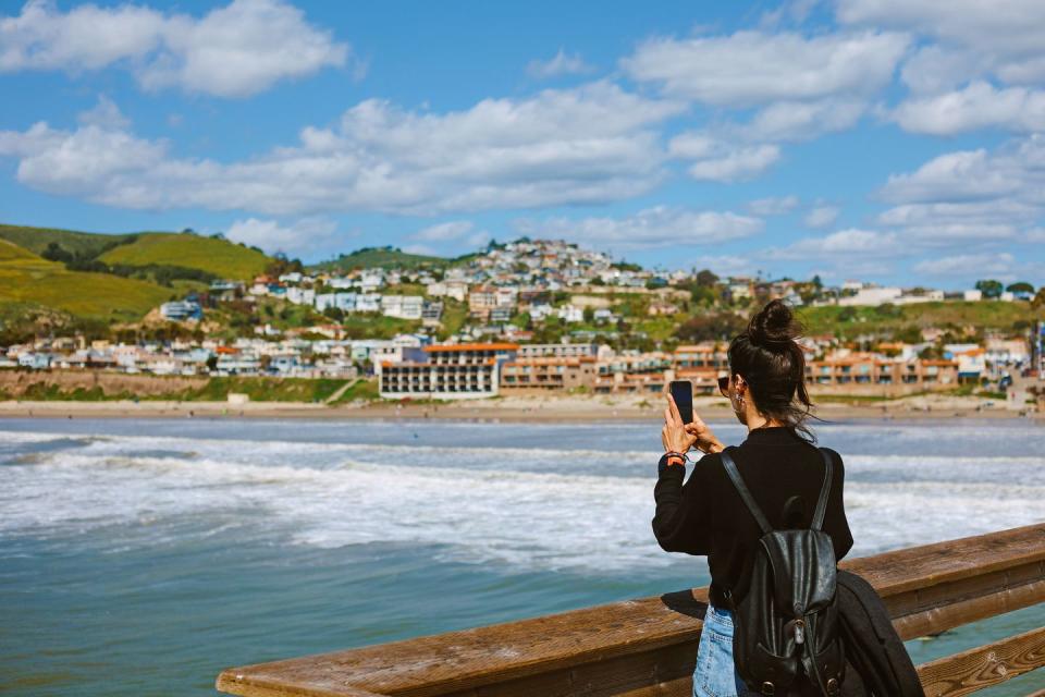 a person taking a picture of a body of water and buildings