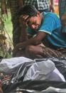 A man cries near the body of a relative, killed in ethnic violence, at a burial ground at Narayanguri village, in the northeastern Indian state of Assam, Saturday, May 3 2014. Police in India arrested 22 people after separatist rebels went on a rampage, burning homes and killing dozens of Muslims in the worst outbreak of ethnic violence in the remote northeastern region in two years, officials said Saturday. (AP Photo/Anupam Nath)