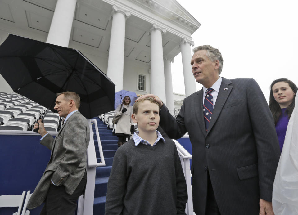 Virginia Gov-elect, Terry McAuliffe, right, and his son, Peter, 11, center, look over the inaugural stand on the South Portico of the Capitol during a walk through at the Capitol in Richmond, Va., Friday, Jan. 10, 2014. McAuliffe is due to be inaugurated as the 72nd Governor of Virginia. (AP Photo/Steve Helber)