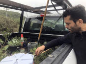 In San Diego, Daniel Watman reviews plants in a pickup truck before driving to Friendship Park within California's Border Field State Park to resurrect the patch that was bulldozed by the Border Patrol earlier this month, on Saturday, Jan. 25, 2020. The U.S. Border Patrol, reacting to a breach it discovered in a steel-pole border wall believed to be used by smugglers, gave activists no warning this month when it bulldozed the U.S. side of a cross-border garden on an iconic bluff overlooking the Pacific Ocean. On Saturday, after a public apology for "the unintentional destruction," the agency allowed the activists in a highly restricted area to resurrect the garden. (AP Photo/Elliot Spagat)