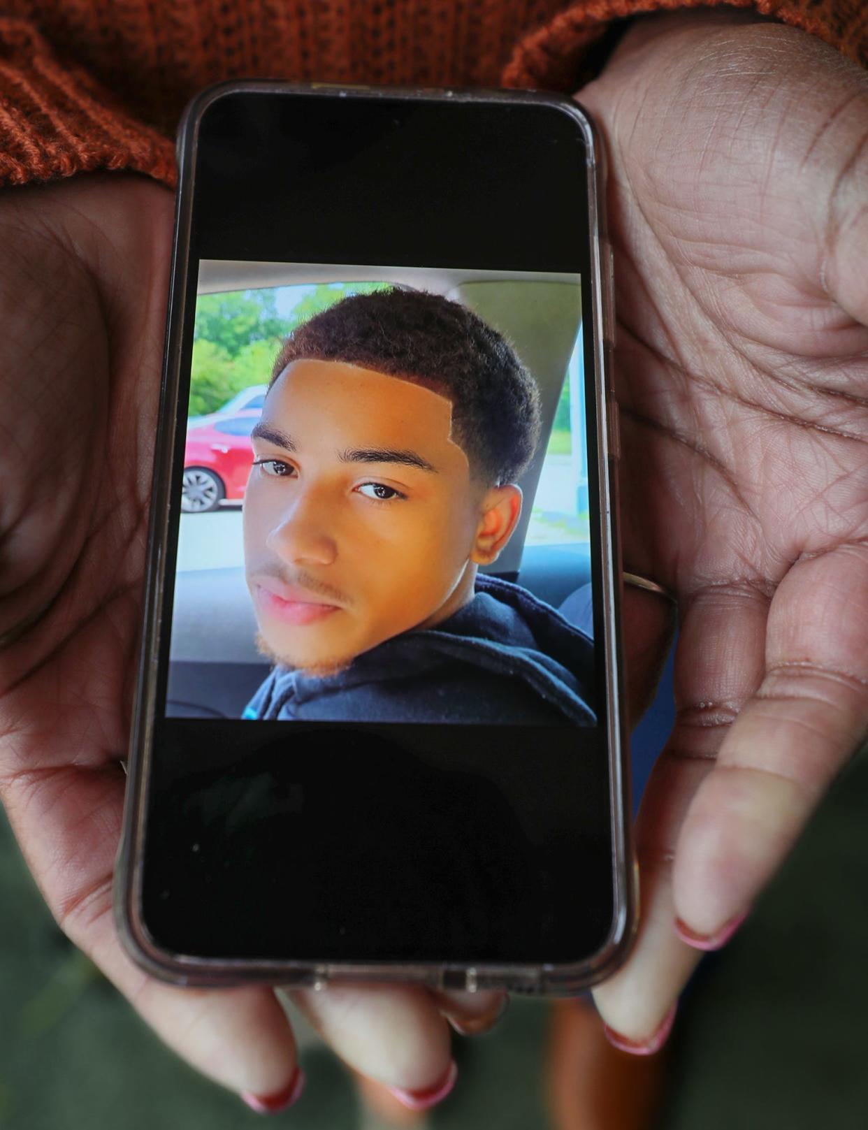 LaTia Snyder shows a photo of her nephew, 17-year-old Antenio Louis, who was shot dead in Akron while catching a ride to football practice.