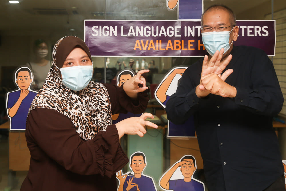 Malaysia Federation of the Deaf honorary secretary Eamiernor Zakiah Md Zuki (left) signs the word for ‘virus’ while executive director Mohamad Sazali Sha’ari makes the sign for ‘Covid-19.’ — Picture by Choo Choy May