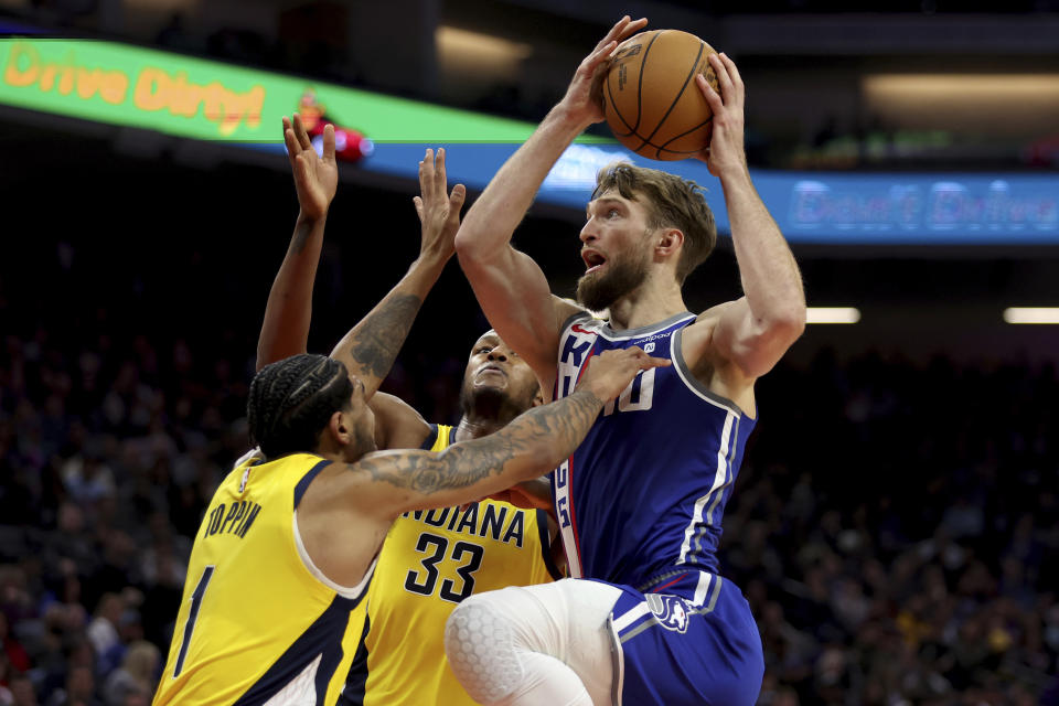 Sacramento Kings forward Domantas Sabonis, right, shoots against Indiana Pacers forward Obi Toppin (1) and center Myles Turner (33) during the first half of an NBA basketball game in Sacramento, Calif, Thursday, Jan. 18, 2024. (AP Photo/Jed Jacobsohn)