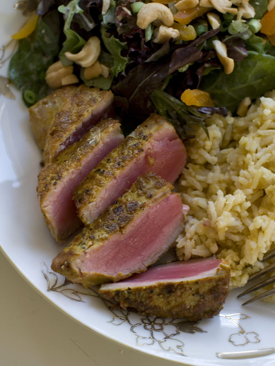 This Nov. 18, 2013 photo shows coconut cashew salad with apricots and seared curry rubbed tuna with mango tahini rice in Concord, N.H. It's a mash-up that draws on the flavors of the Caribbean, Southeast Asia and Europe. (AP Photo/Matthew Mead)