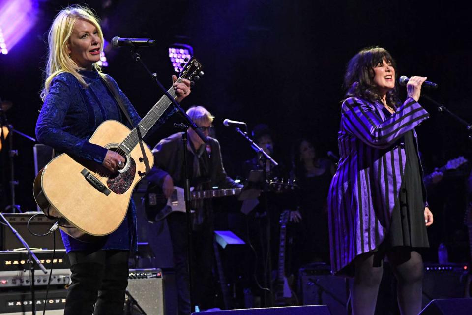 <p>Kevin Mazur/Getty</p> Nancy Wilson and Ann Wilson of Heart performing at the Love Rocks NYC Benefit Concert on March 7, 2019