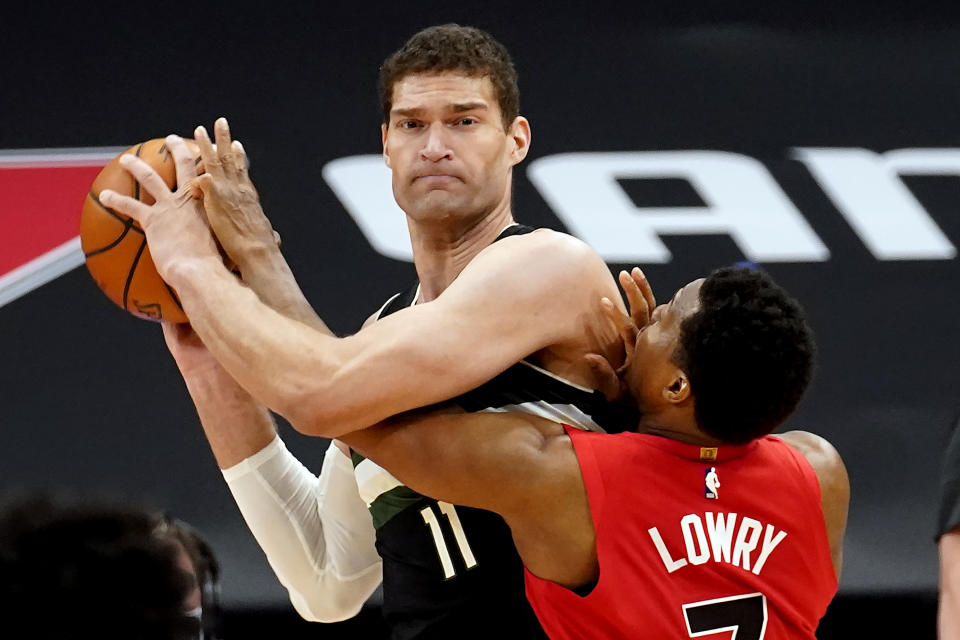 Milwaukee Bucks center Brook Lopez (11) gets tied up by Toronto Raptors guard Kyle Lowry (7) during the second half of an NBA basketball game Wednesday, Jan. 27, 2021, in Tampa, Fla. (AP Photo/Chris O'Meara)