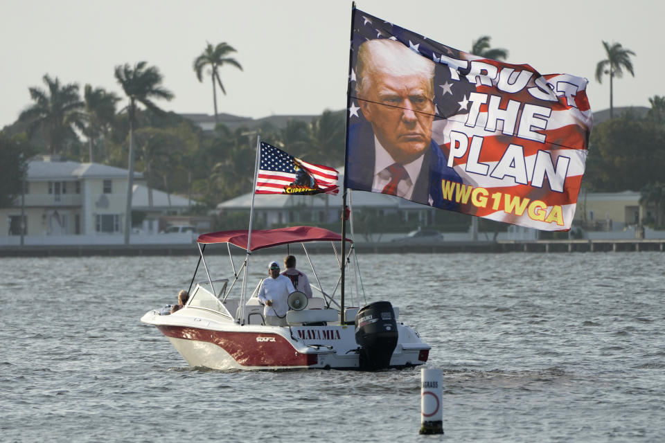 Supporters of former President Donald Trump fly a flag from a boat reading "Trust the Plan" outside of Trump's Mar-a-Lago estate, Saturday, March 18, 2023, in Palm Beach, Fla. (AP Photo/Lynne Sladky)