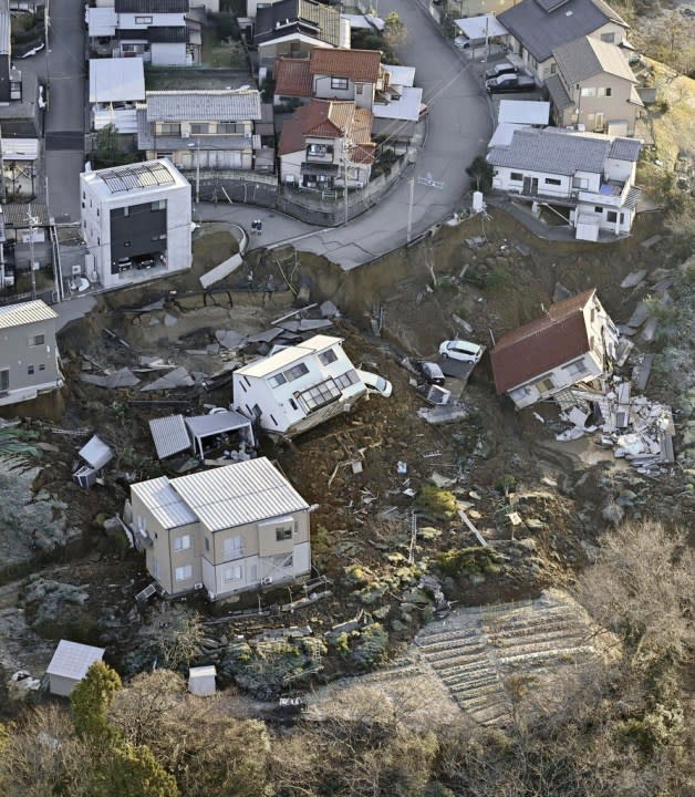 Houses fallen by an earthquake are seen in Kanazawa, Ishikawa prefecture, Japan Tuesday, Jan. 2, 2024. A series of powerful earthquakes in western Japan damaged homes, cars and boats, with officials warning people on Tuesday to stay away from their homes in some areas because of a continuing risk of major quakes and tsunamis. (Kyodo News via AP)
