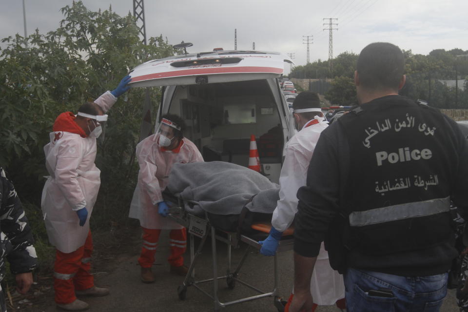 Lebanese Red Cross volunteers transport the body of Lokman Slim, a longtime Shiite political activist and researcher, found dead in his car in the Addoussieh village, in the southern province of Nabatiyeh, Lebanon, Thursday, Feb. 4, 2021. A prominent Lebanese publisher and strong critic of the Shiite militant Hezbollah group has been found dead in his car, shot in the head with two bullets, a security official said Thursday. (AP Photo/Mohammed Zaatari)